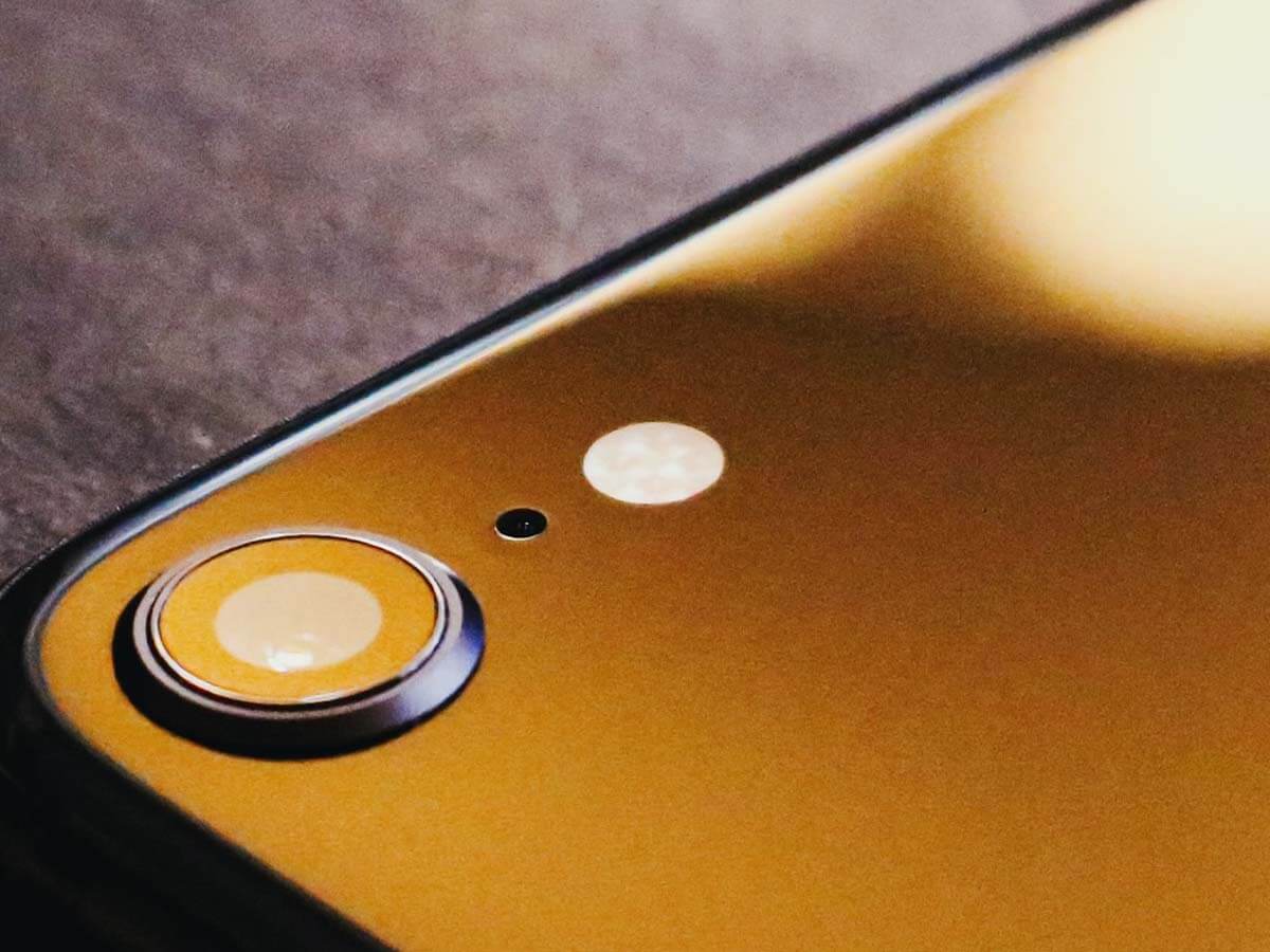 A sleek, black iPhone sitting on top of a felt poker table.